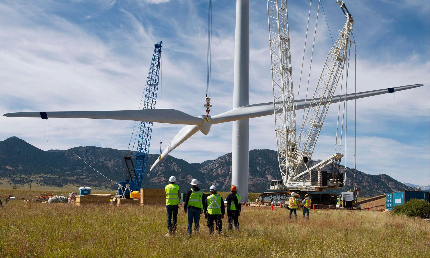 Drone flying near wind turbines to monitor wind energy project progress and infrastructure.