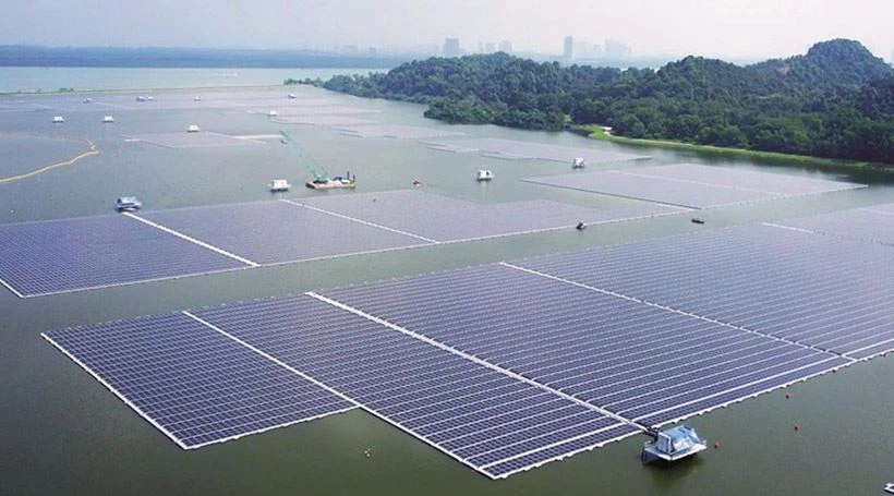 Inspection of solar panels installed on a floating platform over water for renewable energy production.
