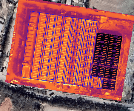 Drone capturing a thermal image of rooftop solar panels during an inspection.