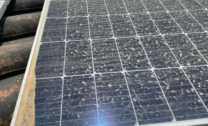 Close-up of a solar panel surface covered in dust, showing reduced efficiency due to dirt buildup.