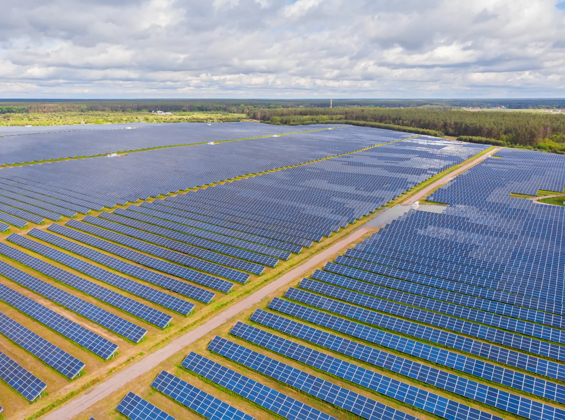 Drone inspecting solar panels at a large solar power plant using thermal imaging technology.
