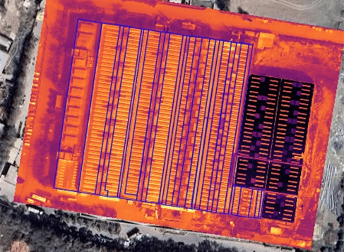 Drone capturing a thermal image of rooftop solar panels during an inspection.