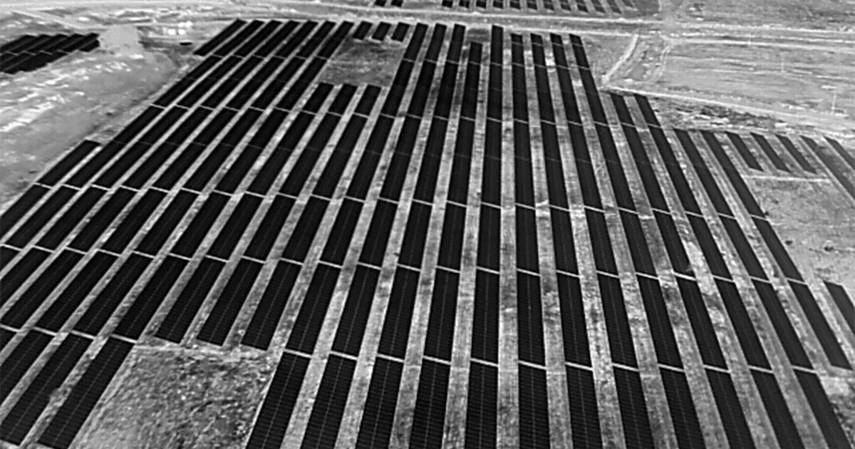 Aerial drone surveillance view of large ground-mount solar power plant at night — 24/7 site monitoring by Lesoko Technologies Chennai