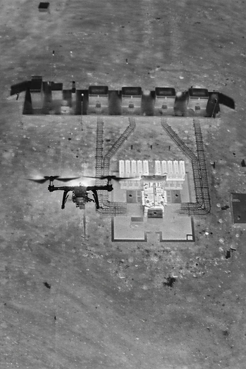 Professional drone inspecting solar power substation and inverter station from aerial view