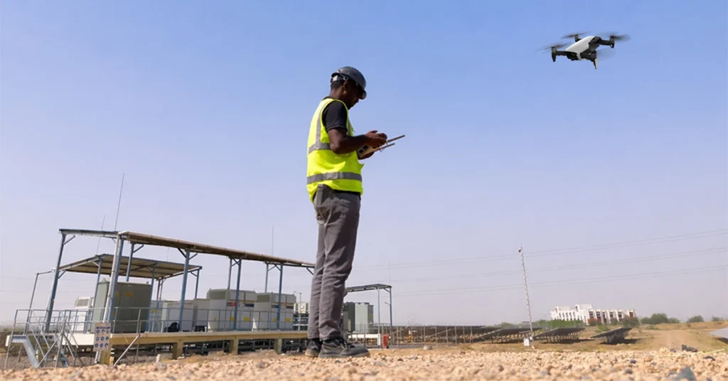 DGCA-certified drone pilot operating UAV at industrial site in India — drone inspection company field survey at solar facility
