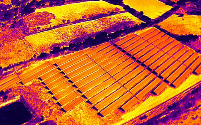 Ground Mount Solar Survey 2 Aerial thermal infrared drone image of a ground mount solar farm in India showing heat signatures of solar panels surrounding vegetation and land parcels — captured during drone thermal inspection by Lesoko Technologies