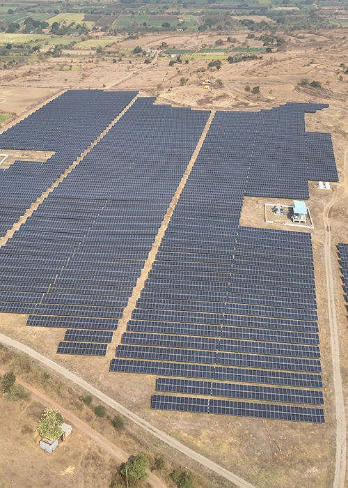 Ground Mount Solar Survey 12 Aerial view of a large-scale ground-mounted solar farm with hundreds of solar panels and a substation building captured during drone survey in India