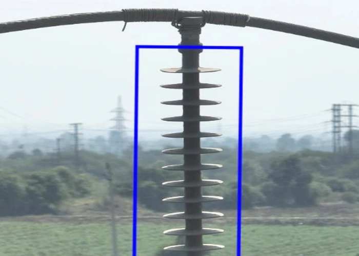 Close-up drone image showing mechanical insulator damage — shed and core break on 33kV transmission tower requiring immediate replacement during power line inspection