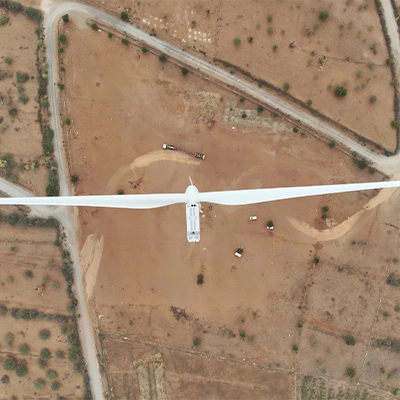 Directly overhead drone survey view of a wind turbine hub and blades, used for turbine micrositing and pad location validation in India