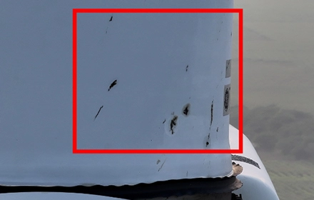 Drone image showing oil pollution and dark surface contamination on wind turbine blade surface, highlighted in red box during UAV inspection in India