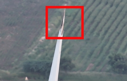 Drone image of wind turbine blade tip showing erosion and structural wear at tip edge, highlighted in red box during aerial UAV inspection in India