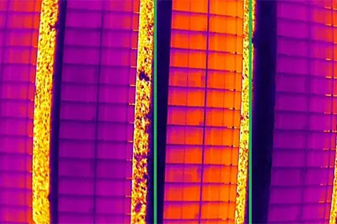Radiometric thermal image showing open circuit fault with irregular hotspot pattern across solar panel strings