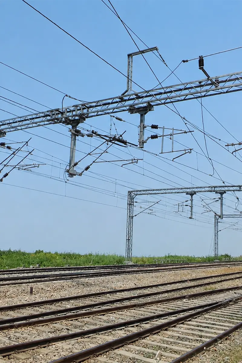 Complex overhead catenary equipment with portal gantry masts, disc insulators, and contact wires spanning multi-track railway junction
