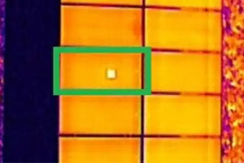 Thermal image showing a single cell-level hotspot highlighted in a solar panel during drone inspection
