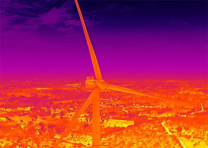 Thermal aerial image of wind turbine and nacelle in false-colour infrared palette, tower prominent against purple sky