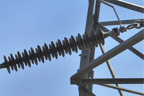 Long composite insulator string with disc sheds mounted at transmission tower cross-arm