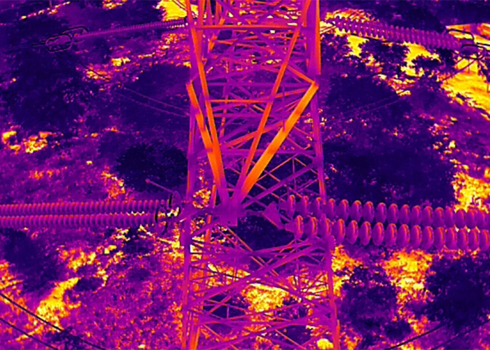 Thermal image of insulator strings on transmission tower cross arm showing temperature contrast